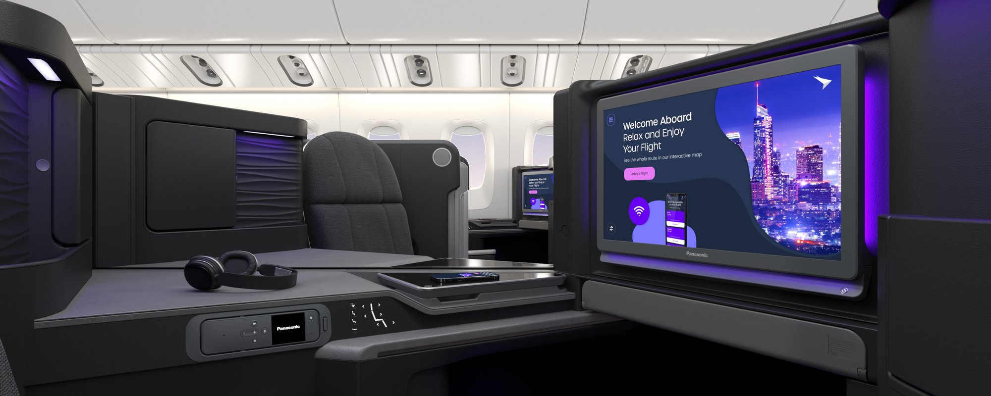 Business class cabin featuring private pods with dark grey seats, personal screens, and overhead bins