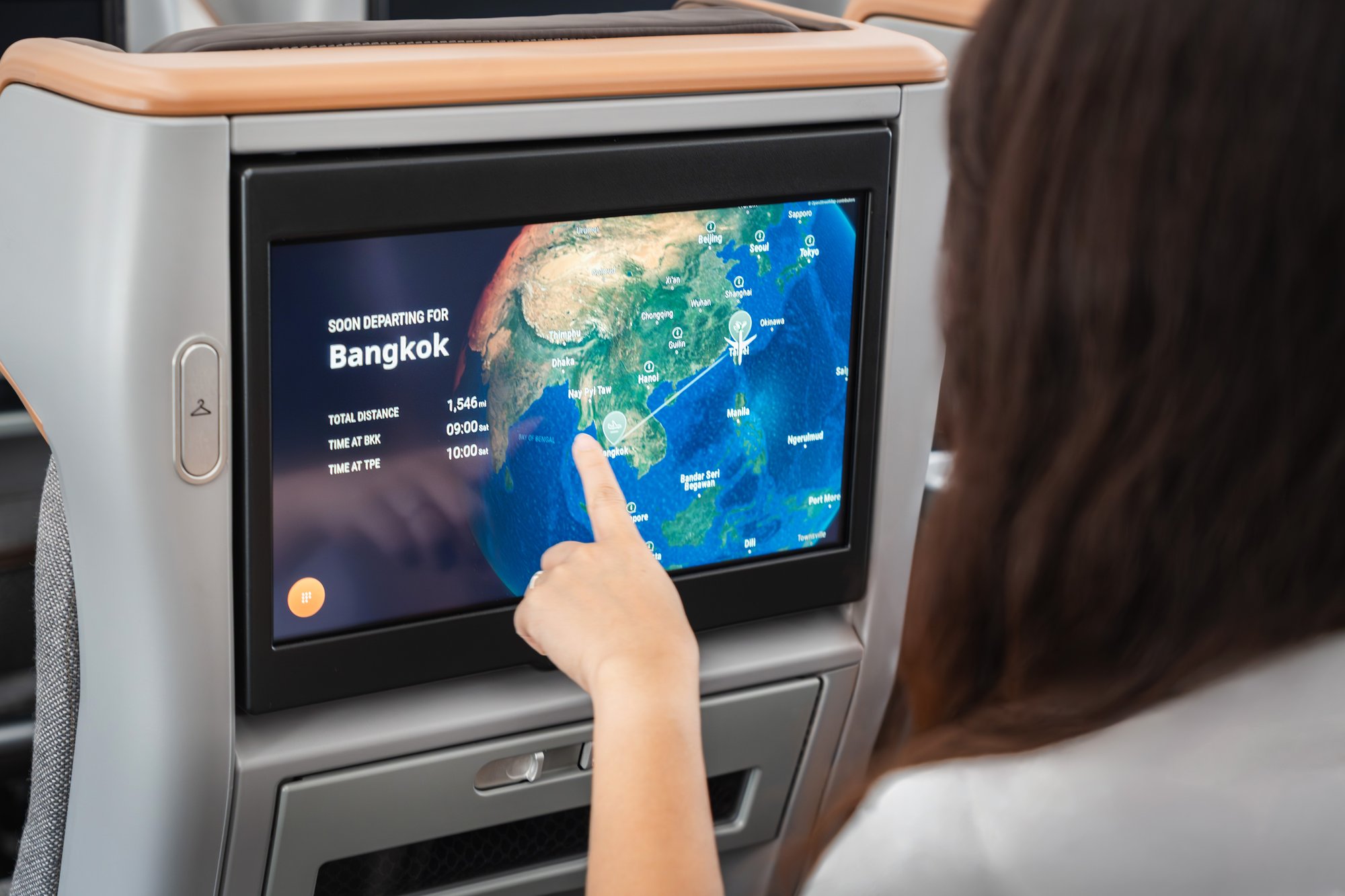 Passenger interacting with Panasonic Avionics Arc map