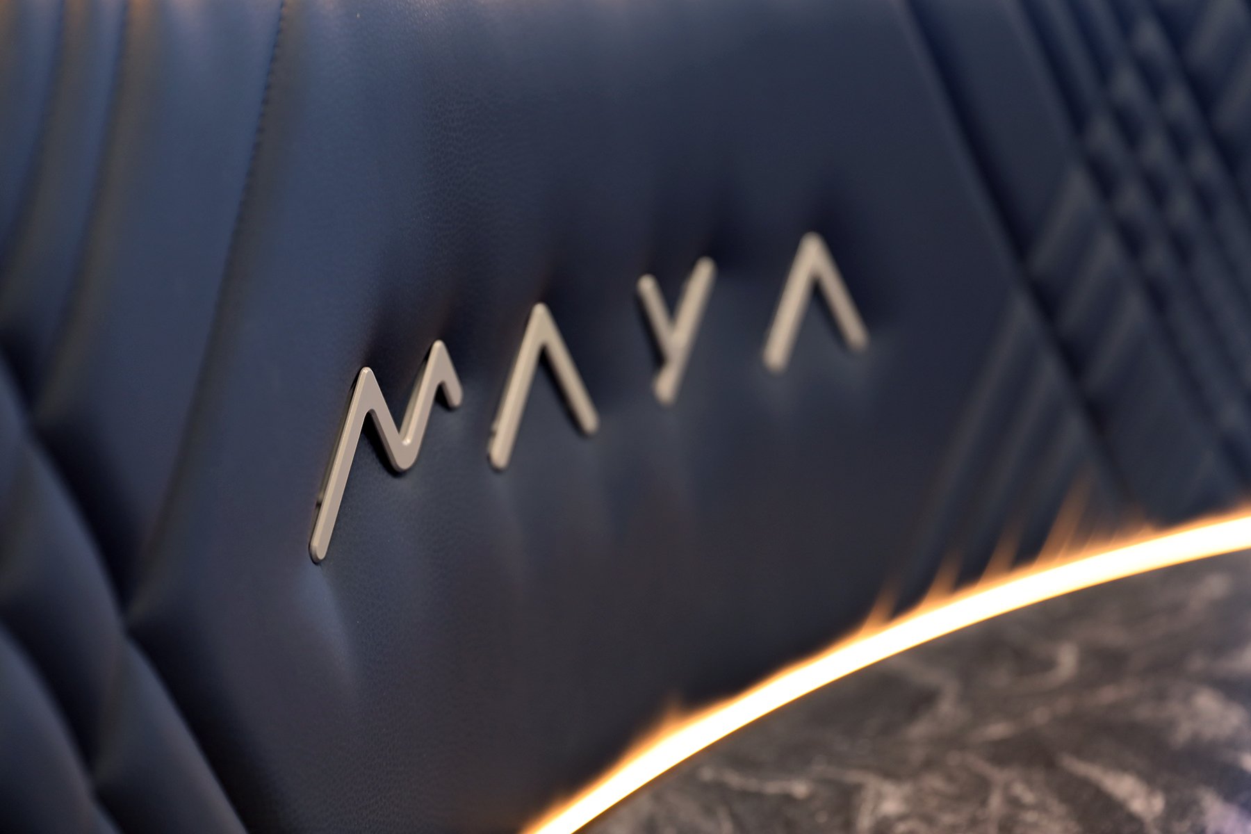 A MAYA emblem on an upholstered material