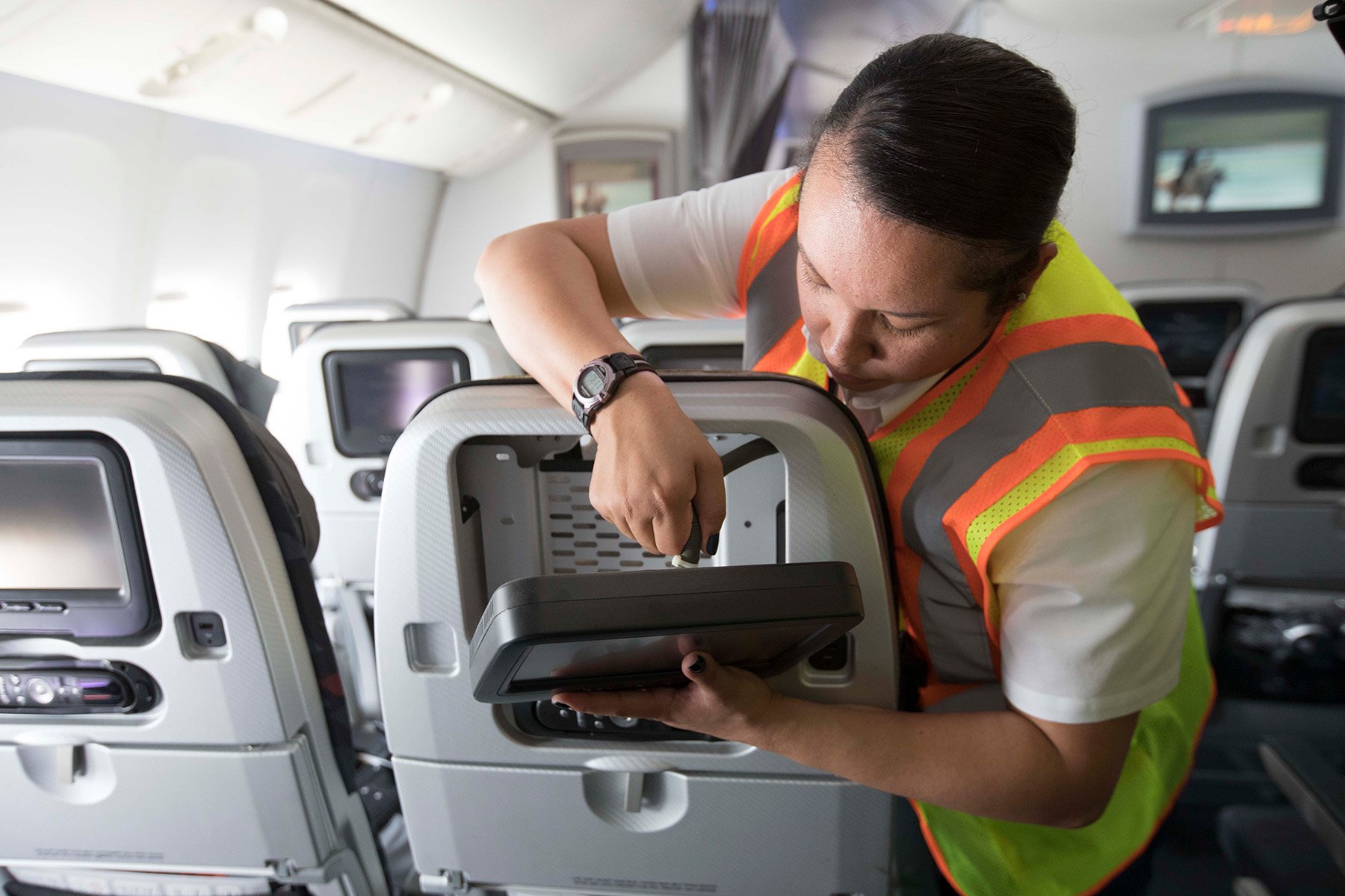 A Panasonic Technical Services team member working on an airplane seatback