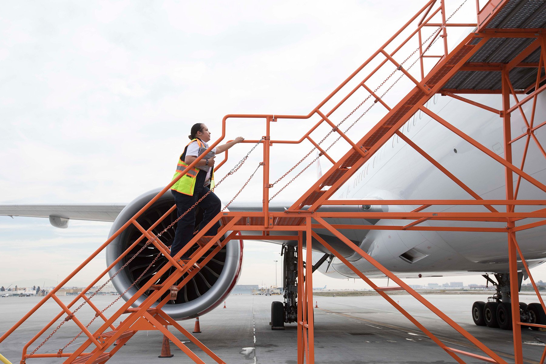 A Panasonic Technical Services team member going up stairs that lead to an airplane
